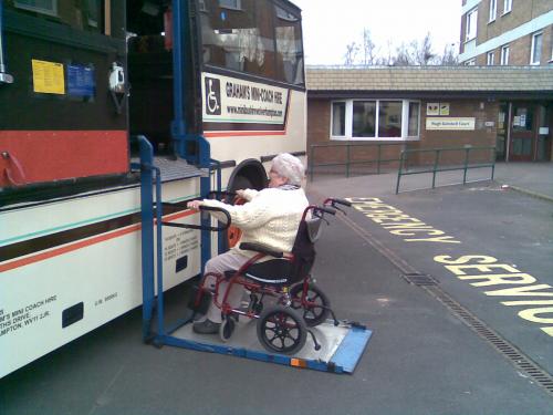 Wheel chair passenger about to be lifted into Coach.